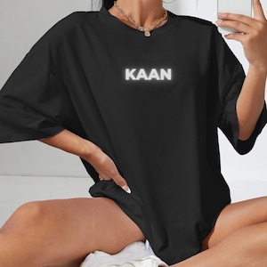 May include: Black oversized t-shirt with a white "KAAN" graphic print.