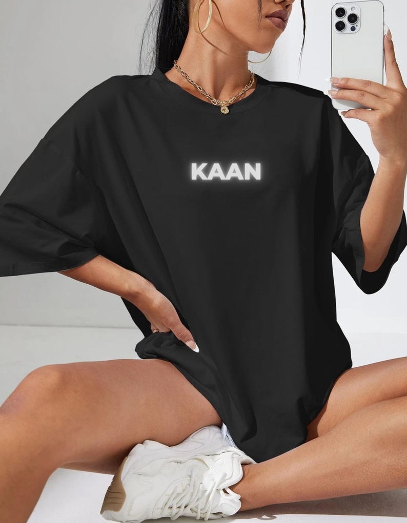 May include: Black oversized t-shirt with a white "KAAN" graphic print.