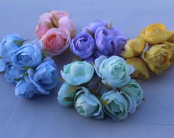 May include: A collection of artificial peony flower bunches in various colors, including light blue, pink, purple, yellow, and seafoam green. Each bunch features multiple blooms and green leaves, perfect for crafting or decorative arrangements.