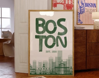 May include: A framed print with the word "BOSTON" in large green letters, with "EST. 1630" below. The print features a green skyline of Boston. Two other framed prints are visible in the background.