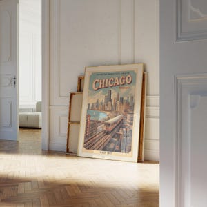 May include: A framed vintage Chicago travel poster. The poster features a cityscape with a train on tracks, the word "Chicago" in large letters, and the text "Illinois" below. The poster is leaning against a wall.