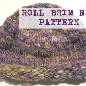 May include: A purple, brown and beige knitted hat with a rolled brim. The hat has a text label that reads "ROLL BRIM HAT PATTERN".