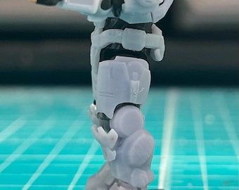 May include: A grey plastic action figure of a soldier wearing a helmet and armour. The figure is standing on a black base.