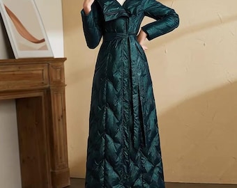 May include: A long, quilted emerald green coat with a hood and a matching belt. The coat has a diamond pattern and is worn with brown boots. The coat is a stylish outerwear garment.