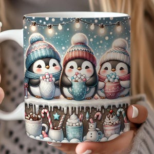 Könnte beinhalten: Weiße Keramik-Tasse mit drei Cartoon-Pinguinen, die Wintermützen und Schals tragen und Tassen mit Marshmallows halten. Die Tasse hat ein Winterthema mit Lichterketten und Heißschokoladen-Designs am Boden.