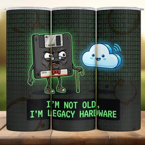May include: A cylindrical tumbler featuring a binary code background and three cartoon graphics: a grumpy floppy disk, a smiling cloud, and the text "I'M NOT OLD, I'M LEGACY HARDWARE."