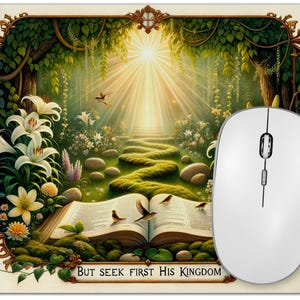 Puede incluir: Alfombrilla de ratón decorativa con una ilustración detallada de un camino soleado que conduce a una luz brillante. La imagen incluye un libro abierto, pájaros y el texto "BUT SEEK FIRST HIS KINGDOM". Un ratón blanco está a la derecha.