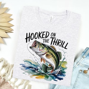 a t - shirt that says hooked on the thrill with a fish on it