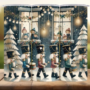 Puede incluir: Un vaso con un diseño invernal. Representa soldados de juguete marchando en una escena nevada, con niños mirando por las ventanas. El diseño incluye luces navideñas y pinos cubiertos de nieve.