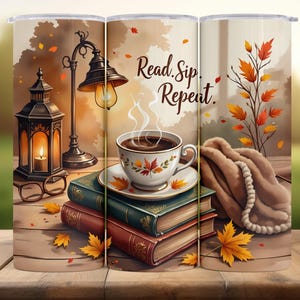 以下が含まれることがあります： 秋のシーンが描かれたタンブラー。コーヒーカップ、本、紅葉が描かれています。「Read. Sip. Repeat.」の文字が表示されています。ランタンとランプも表示されています。
