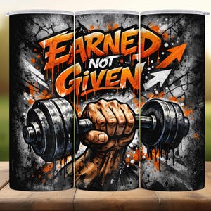 May include: A stainless steel tumbler with a motivational design. The tumbler features the text "EARNED NOT GIVEN" in orange, with a hand gripping a dumbbell. The background is a mix of gray and black with orange accents.