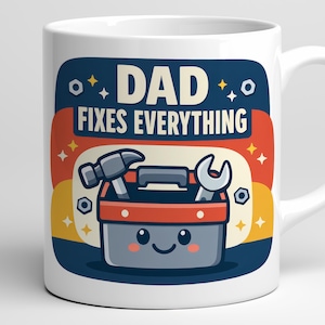 Könnte beinhalten: Weißer Keramikbecher mit einer farbenfrohen Grafik. Das Design zeigt den Text "DAD FIXES EVERYTHING" über einer Cartoon-Werkzeugkiste mit Hammer und Schraubenschlüssel. Die Werkzeugkiste hat ein lächelndes Gesicht und ist vor einem blauen, orangefarbenen und gelben Hintergrund.