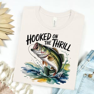 a t - shirt that says hooked on the thrill with a fish on it