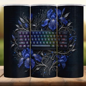 May include: A black tumbler featuring a mechanical keyboard with rainbow-colored keys, surrounded by blue iris flowers and circuit board designs. The background is dark blue with a subtle texture, creating a tech-floral theme.