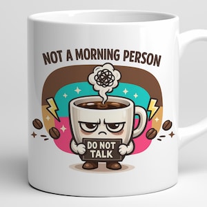 Puede incluir: Taza de café de cerámica blanca con una ilustración de dibujos animados. La taza presenta un personaje de taza de café gruñón que sostiene un letrero que dice "DO NOT TALK". La taza también tiene el texto "NOT A MORNING PERSON".