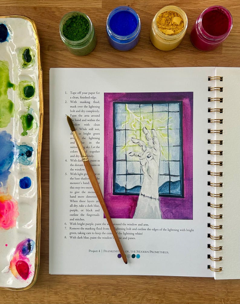 Puede incluir: Un diario de arte abierto con una ilustraci&oacute;n en acuarela de una mano que alcanza un rayo. Un pincel descansa sobre la p&aacute;gina. Frascos de pintura azul, amarilla, verde y roja est&aacute;n cerca, junto con una paleta de cer&aacute;mica.