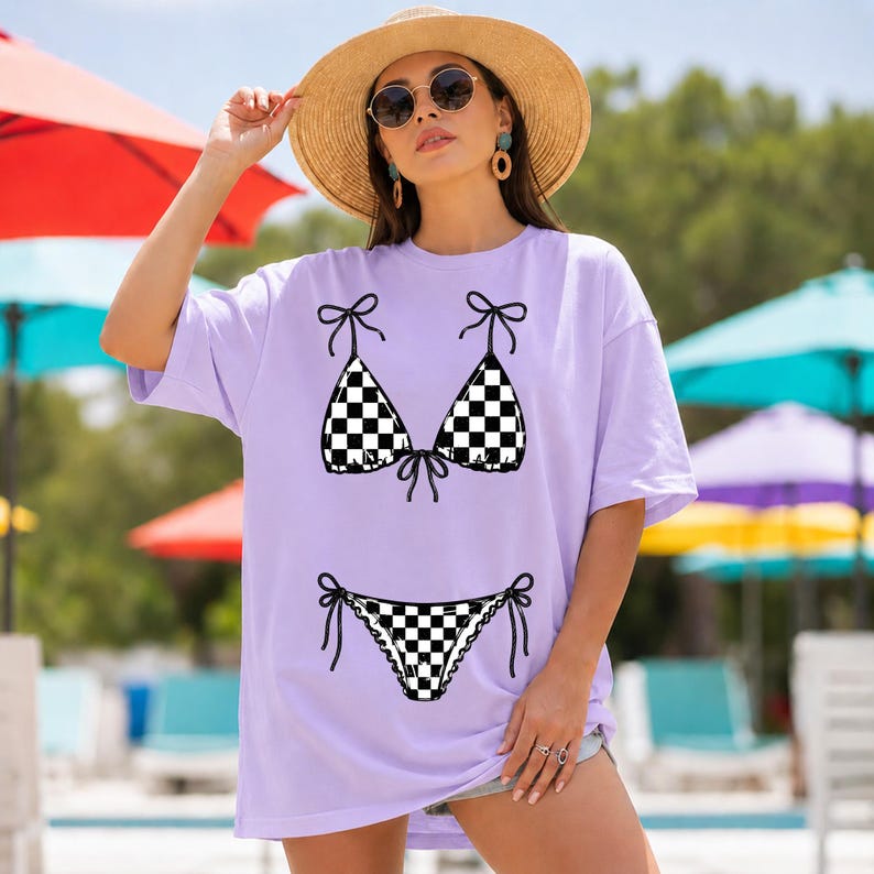 以下が含まれることがあります： 黒と白のチェック柄ビキニのデザインが施された、薄紫色のTシャツ。 ビキニのトップスとボトムは、リボンのディテールで描かれています。 このシャツはカジュアルなオーバーサイズスタイルです。