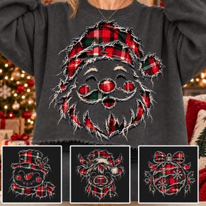 May include: A dark gray sweatshirt featuring a distressed-look graphic of a Santa Claus face in red, green, and black plaid. The design has frayed edges. Smaller inset images show a snowman, a highland cow, and a Christmas ornament in the same style.