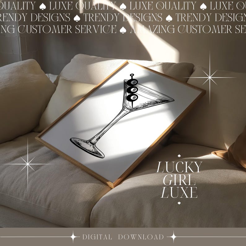 May include: A digital download of a minimalist black and white illustration of a martini glass with three olives. The text 'LUCKY GIRL LUXE' is displayed below the illustration. The image is displayed on a beige couch. The text at the top reads 'QUALITY LUXE QUALITY LUXE QUALITY LUXE' and 'TRENDY DESIGNS TRENDY DESIGNS TRENDY DESIGNS'. The bottom text reads 'DIGITAL DOWNLOAD'.