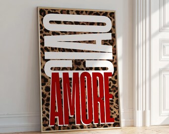May include: A framed art print with a leopard print background. The words "CIAO" and "AMORE" are displayed in large, bold letters. "CIAO" is in white, and "AMORE" is in red. The print is leaning against a white wall.