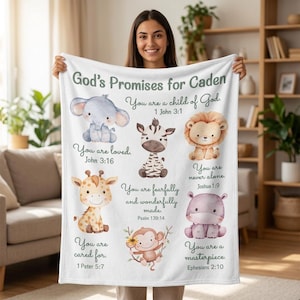 May include: A white fleece blanket featuring the text God's Promises for Caden and illustrations of a baby elephant, zebra, lion, giraffe, monkey, and hippo. Each animal is paired with a religious verse including 1 John 3:1 and John 3:16.