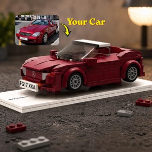 May include: A brick-built, claret-coloured car model with a white roof and clear windscreen. The model sits on a white base, with the license plate reading "FG17 XKA". An image of a red convertible is in the upper left corner, with the text "Your Car".