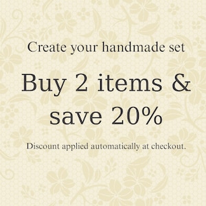 May include: A cream-colored graphic with a subtle floral pattern and dark brown text that reads: Create your handmade set, Buy 2 items & save 20%, Discount applied automatically at checkout. The design features a repeating lace-like background.