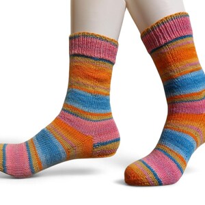 Op de afbeelding: Een paar kleurrijke sokken met horizontale strepen in roze, oranje, blauw en geel. De sokken worden gepresenteerd tegen een witte achtergrond, waarbij het levendige kleurenpalet en de gebreide textuur worden benadrukt. De sokken zijn ontworpen om gedragen te worden.