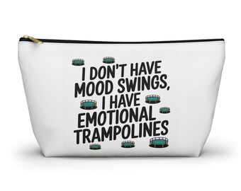 May include: White zippered pouch with the text "I don't have mood swings, I have emotional trampolines" in black. The design includes small trampoline graphics. The pouch has a gold zipper.