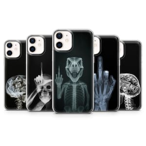 May include: A collection of black phone cases featuring x-ray images. Designs include a skull, a brain filled with money, and a dinosaur skeleton giving the middle finger. The cases have a clear border.