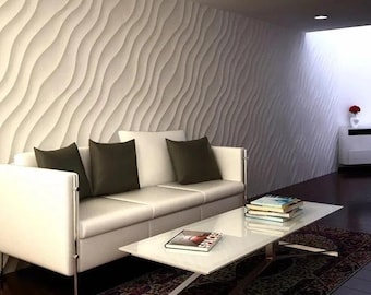 May include: A white sofa with three cushions and a white coffee table with a stack of books on it. The sofa is in front of a wall with a white wave pattern.
