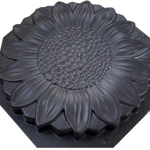 May include: A black plastic mold for making concrete stepping stones in the shape of a sunflower.
