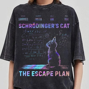 Può includere: T-shirt grigio scuro con una grafica di un gatto e delle equazioni scientifiche. Il testo sulla maglietta recita "Schrödinger's Cat" e "The Escape Plan" in un carattere iridescente colorato. La maglietta ha un aspetto vintage.