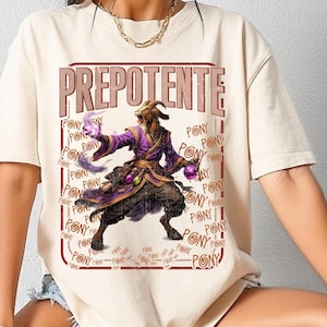 Peut inclure: T-shirt beige avec le mot "PREPOTENTE" en marron, police vieillie. Le t-shirt présente une illustration fantastique d'une créature ressemblant à une chèvre en robes violettes, tenant des orbes. Le mot "PONY" est répété.