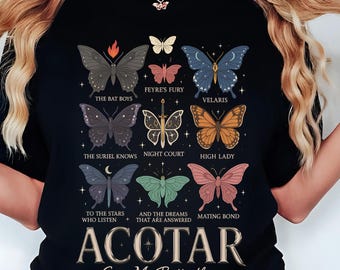 May include: A black t-shirt with a graphic of butterflies and text that reads "ACOTAR Give Me Butterflies". The butterflies are stylized and have different colors and patterns. The text is in white and is centered on the shirt.