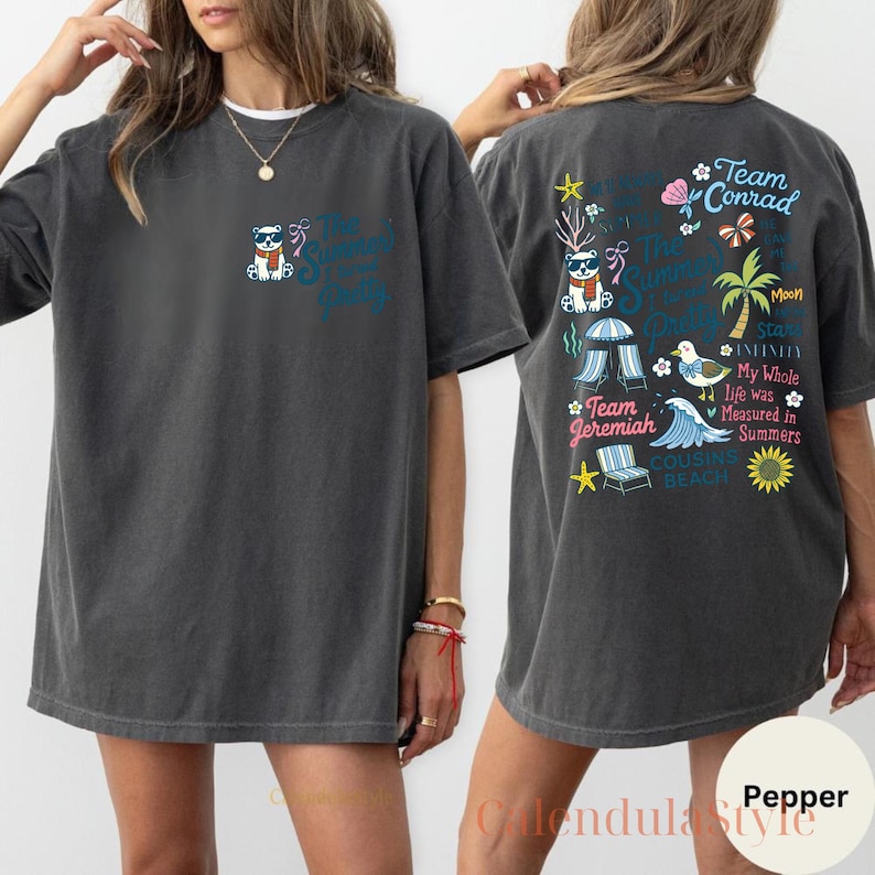May include: Dark gray t-shirt with a graphic on the front and back. The front features a cartoon bear wearing sunglasses and a scarf, with text that reads "The Summer Squad". The back has more graphics and text including "Team Conrad" and "Team Jeremiah".