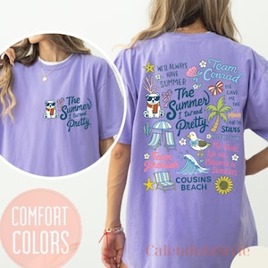 May include: A lilac-colored t-shirt with a graphic on the front that says "The Summer I turned Pretty" and a cartoon bear wearing sunglasses and a scarf. The back of the shirt has a summer-themed design with text and illustrations.