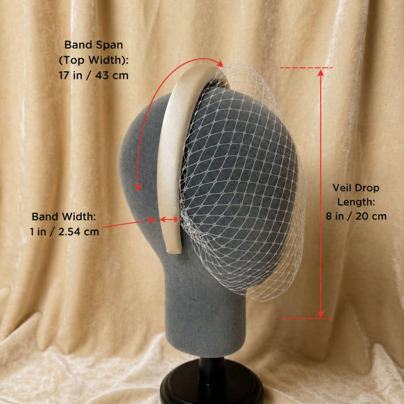 Op de afbeelding: Een cr&egrave;mekleurige haarband met sluier, getoond op een mannequinhoofd. De bovenste breedte van de haarband is 43 cm, en de bandbreedte is 2,54 cm. De sluierlengte is 20 cm.