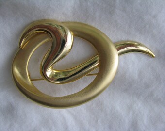 Bold and dramatic gold tone brooch pin textured and smooth swirl design