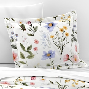 May include: A white pillowcase with a floral pattern featuring blue, pink, and yellow flowers on a white background.