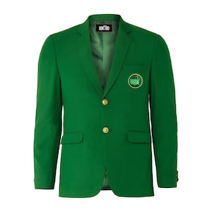 Puede incluir: Una chaqueta verde con botones dorados y un parche en el pecho izquierdo que presenta un contorno verde de los Estados Unidos con una bandera de golf sobre un fondo blanco. El texto "GOK100" es visible en el interior del cuello.