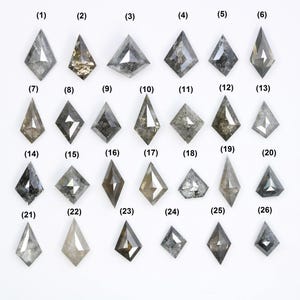 May include: Twenty-six grey, rough-cut, diamond-shaped gemstones arranged in rows on a white background. Each gemstone is labeled with a number from 1 to 26.