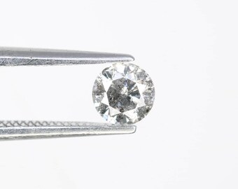May include: A round, clear diamond with a gray center, held in tweezers.