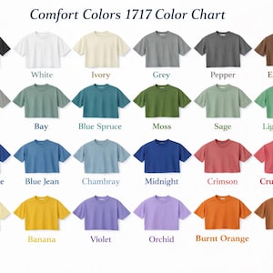 May include: A colour chart of Comfort Colors 1717 t-shirts, showcasing a spectrum of shades such as black, white, and blue. The chart presents a variety of hues, from muted tones to bright colours, with each shirt labelled.