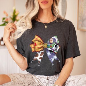 May include: A white ceramic mug with a black handle and the text "But First, Coffee" in a black, bold font. The mug is on a white surface.