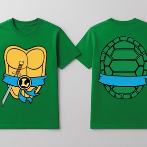 May include: Green t-shirts with a cartoon design. One shirt features a yellow turtle shell with a blue ribbon, a sword, and a letter "L". The other shirt shows a turtle shell design on the back with a blue ribbon.