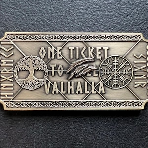 May include: A metal ticket to Valhalla with the text "One Ticket to Valhalla" and a tree of life, a feather, and a runic symbol.