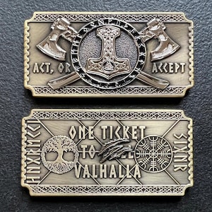 May include: Two gold-colored metal ticket replicas. The top ticket features a hammer and two axes with the text "Act, or Accept". The bottom ticket features a tree, a bird, a symbol, and the text "One Ticket to Valhalla".