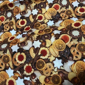 Puede incluir: Tela con un patrón repetido de varias galletas, rodajas de naranja deshidratadas y galletas en forma de estrella. Las galletas son en tonos marrón, beige y blanco, con relleno de mermelada roja. También son visibles palitos de canela y nueces.