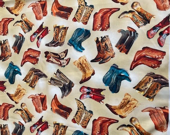 Könnte beinhalten: Ein beigefarbener Stoff mit einem sich wiederholenden Muster aus bunten Cowboystiefeln. Die Stiefel sind in verschiedenen Stilen und Farben, darunter Braun, Blau, Rot und Gelb.